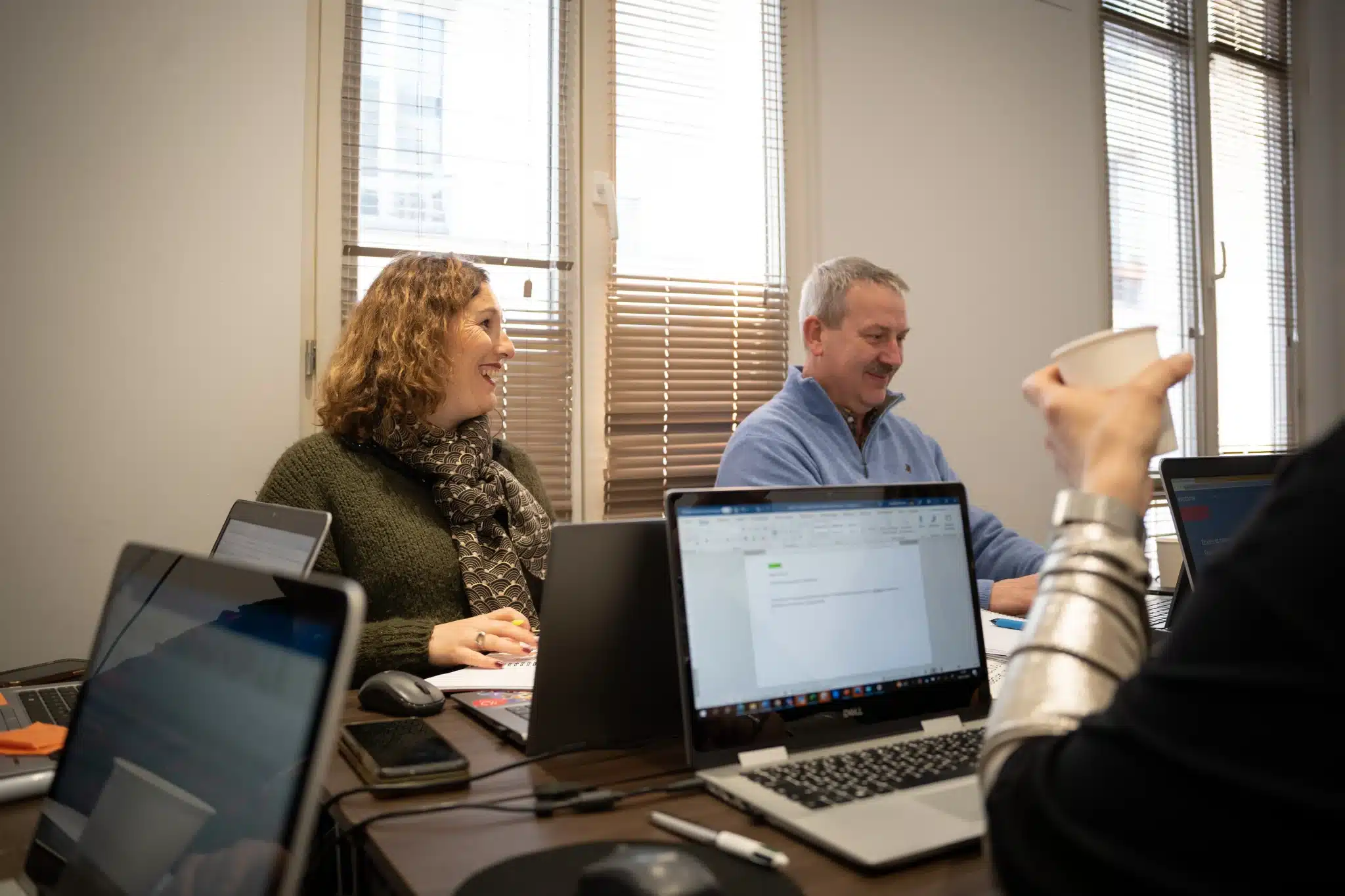Collaborateurs sur leurs ordinateur pendant une réunion